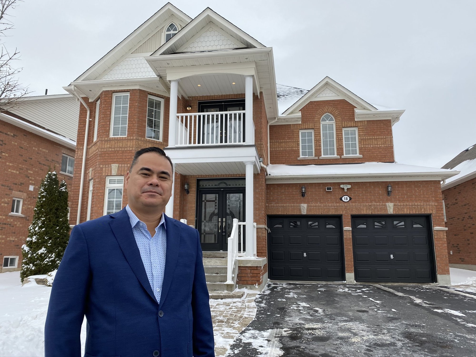 Real estate agent in front of a house for sale in Brooklin, Ontario