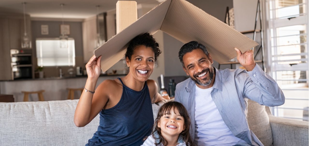 Family holding a cardboard roof over their head signifying home insurance