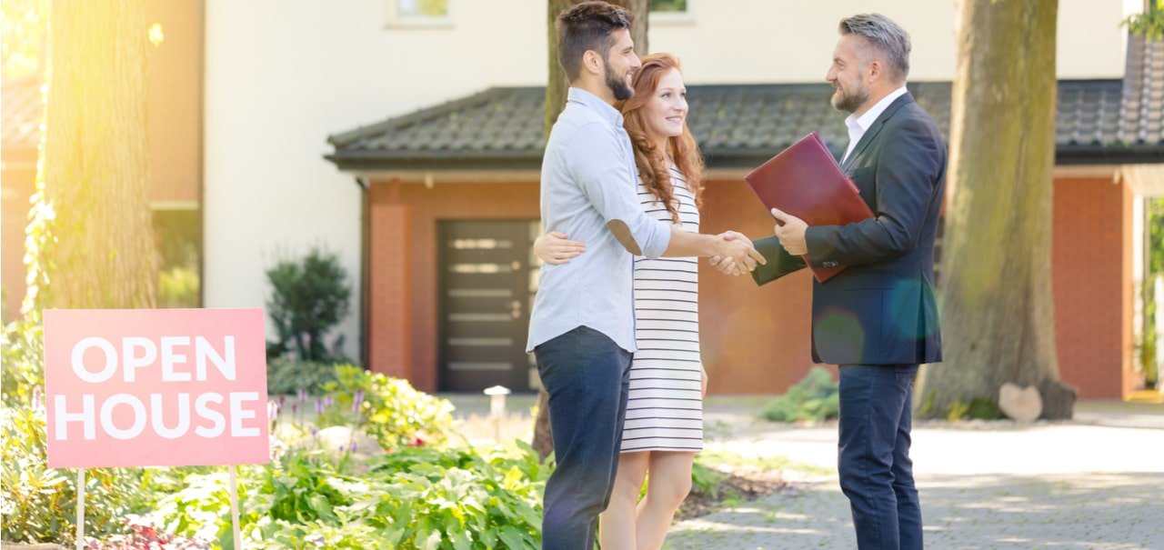 Couple shaking hands with a realtor at an open house