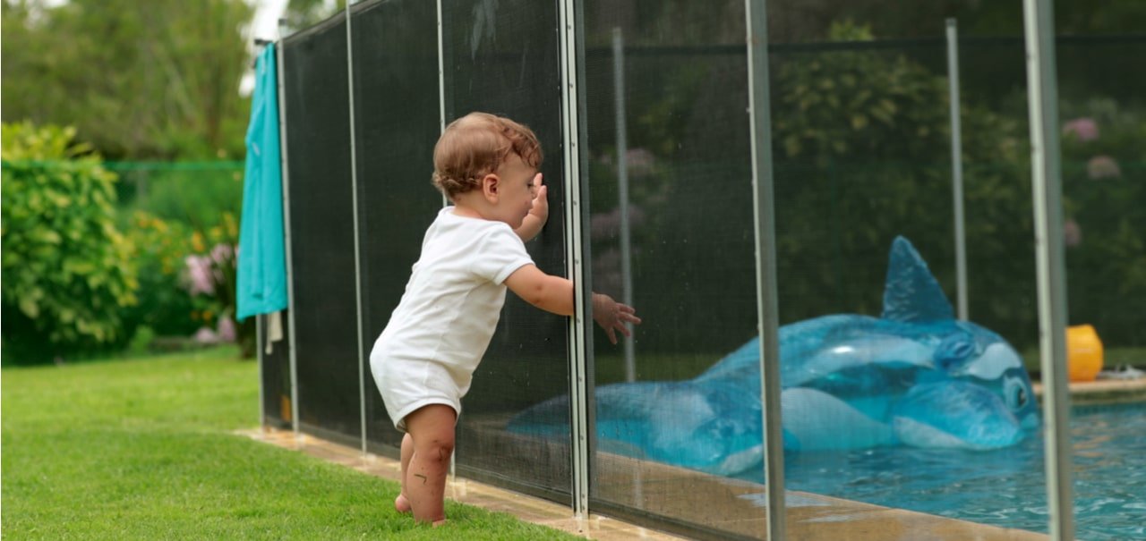 Child trying to get in the fenced in swimming pool 